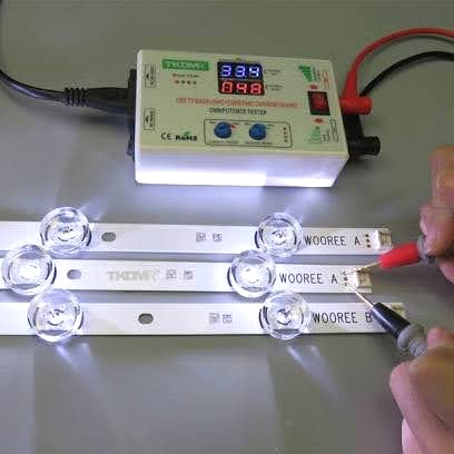 LED backlight strips being tested with a digital meter