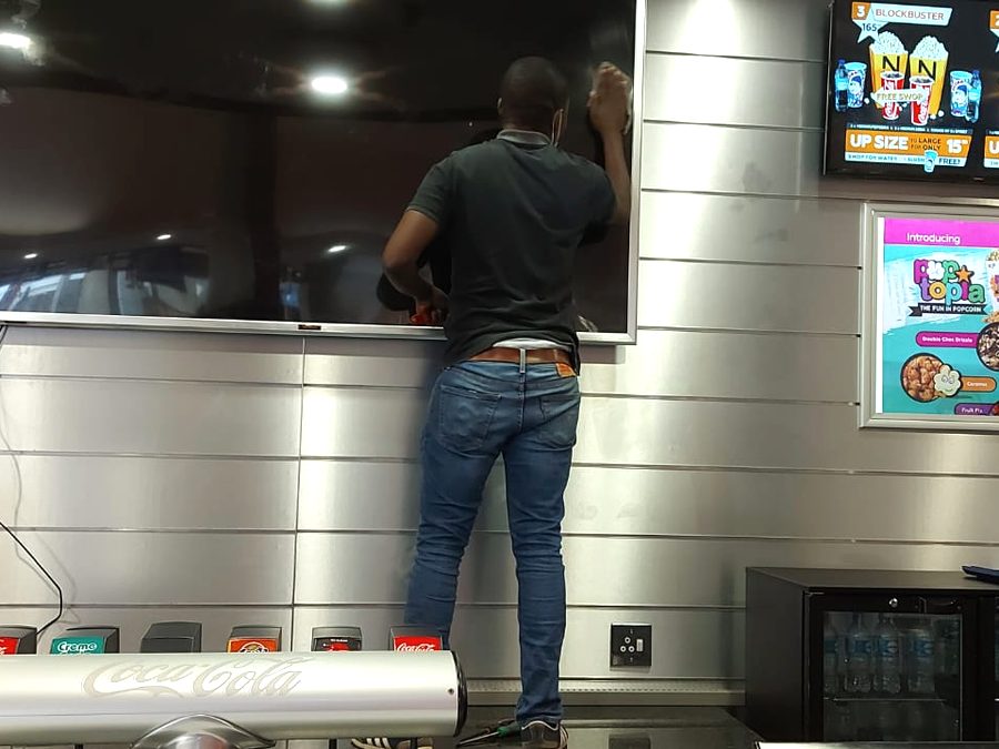 Technician working on wall-mounted televisions on site