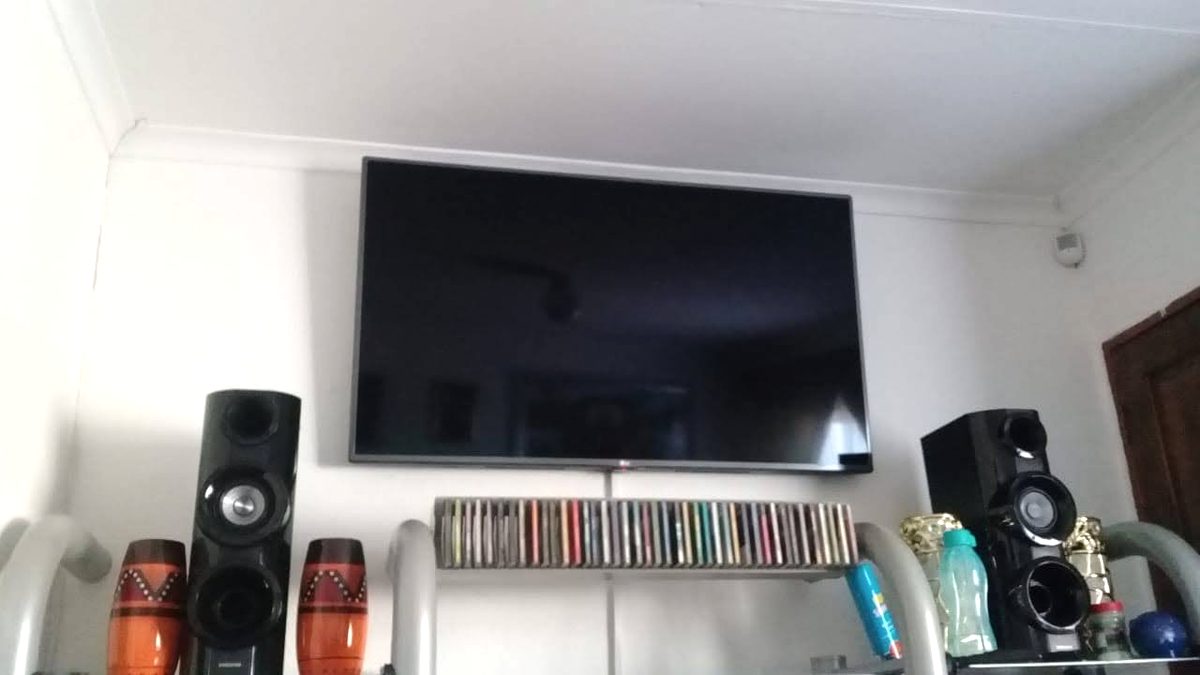 Wall-mounted television installed above a home sound system